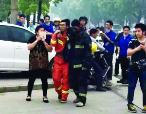 事故現場,受傷的消防隊員被隊友攙扶到一邊休息 事故現場,受傷的消防隊員被隊友攙扶到一邊休息